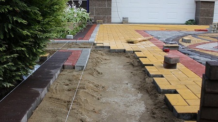 Укладка тротуарной плитки во дворе загородного дома: основные этапы